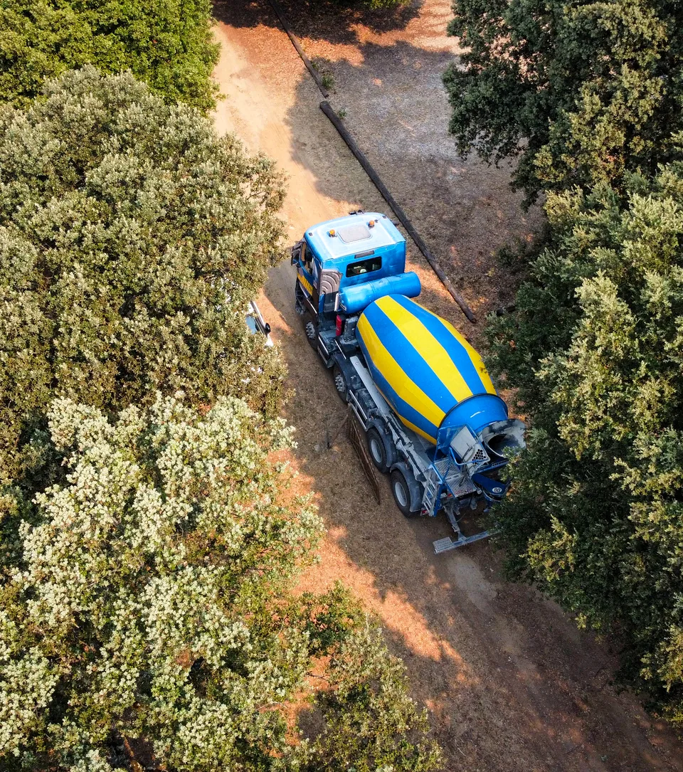 Camion-malaxeur BCGA vu du ciel sur un chemin de garrigue, entre les chênes