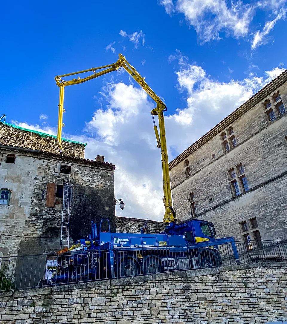 Camion-pompe BCGA flèche déployée au-dessus des maisons de pierre de Barjac