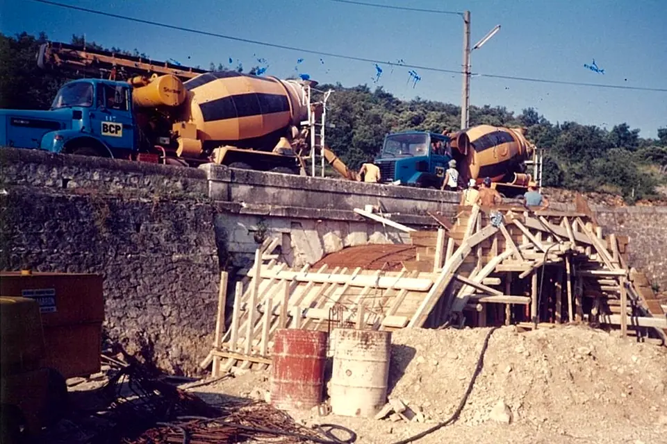 Deux camions-malaxeurs sur un pont en construction en 1988, au-dessus du cintre en bois de l’arche