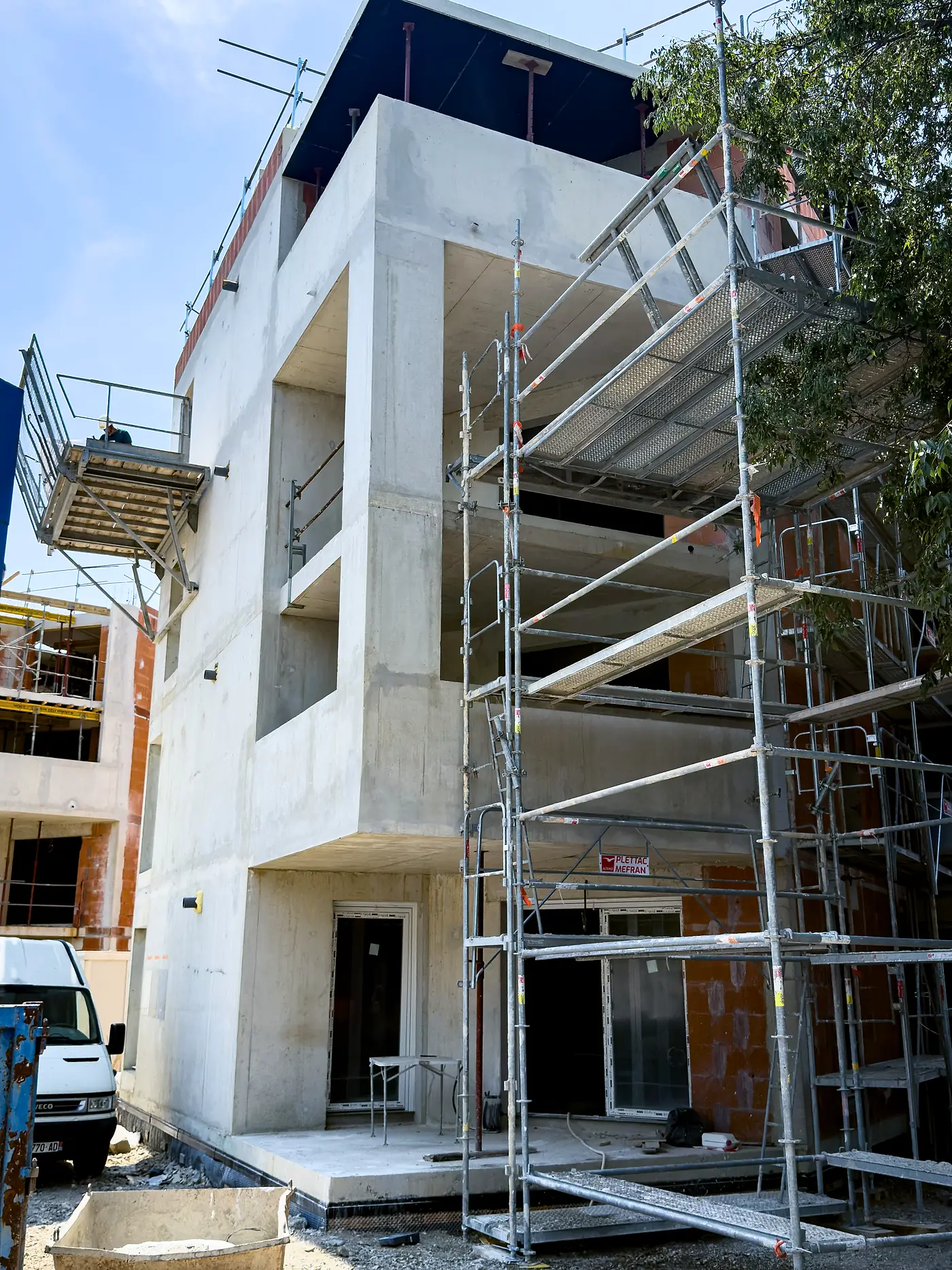 Immeuble en construction sous échafaudage, voiles et planchers en béton
