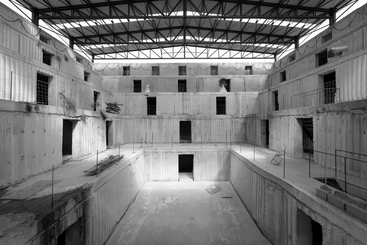 L’amphithéâtre de la Fondation Kiefer à Barjac, murs de béton étagés et percés d’ouvertures autour d’une fosse, sous une charpente métallique